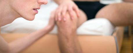 HIV/AIDS und Oralverkehr: Beim Oralsex kommt es nur äußerst selten zu einer HIV-Infektion. Im Vordergrund der Mund einer Person, im Hintergrund eine sitzende Person in Boxershorts.