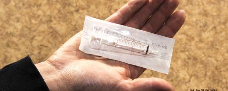 Safer Use: Hygiene beim Drogengebrauch In einer ausgestreckten Hand liegt eine steril verpackte Spritze